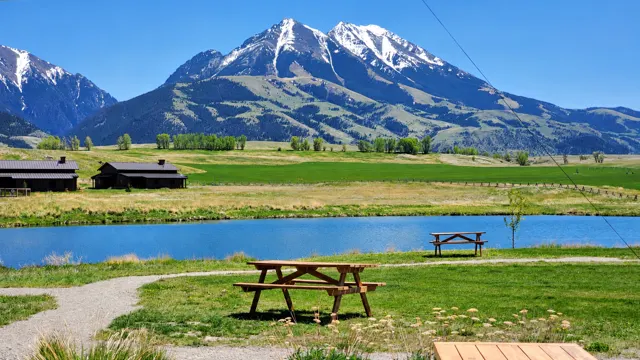 Snowy peaks above a pond and picnic table in Paradise Valley