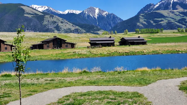 Cabins along a pond under snowy mountains in Paradise Valley